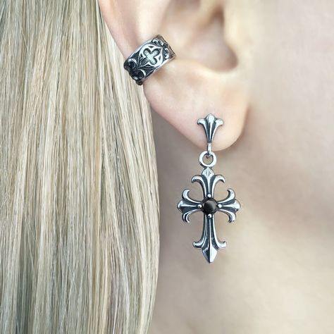 Gothic Cross Earring, a striking piece of jewelry that embodies the essence of gothic style and dark elegance. Crafted with meticulous attention to detail, this earring is designed to make a bold statement and add a touch of mystique to any outfit. Sold as Single or Pair Material : 316 Stainless steel Set with Black and Clear Cubic Zirconia Size: 38 mm long Closure: Butterfly push back Listing for pair of earrings only Goth Ear Stack, Elegant Piercings, Moodboard Jewelry, Gothic Moodboard, Gothic Piercings, Goth Piercings, Alt Earrings, Dark Accessories, Dark Earrings