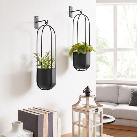 Summer home decor just got better with these stunning wall planters! Meet the Walter 2-Piece Modern Black Metal Oval Hanging Planter Set. Say goodbye to bare and boring walls, and hello to these modern planters. Hang them in your living room, bedroom, kitchen, or garden to add some greenery! #danyabhome #homedecor #interiordesign #homestyle #interiorinspo #wallplanters #modernhomedecor #modernminimalism Metal Hanging Planters, Black Planters, Hanging Frames, Hanging Planter, Wall Planter, Oval Frame, Hanging Planters, Outdoor Shade, Black Metal