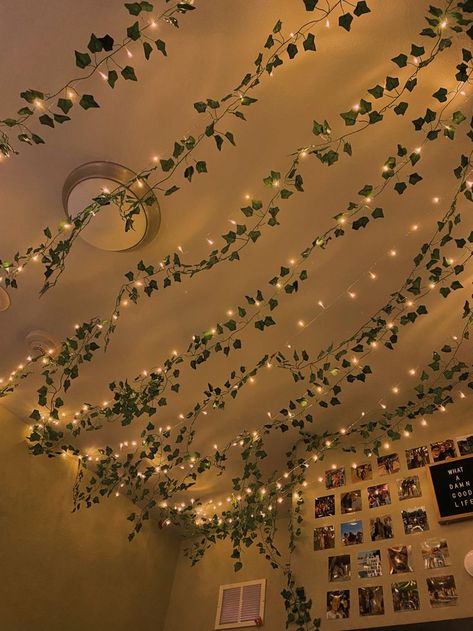 A comfy looking, aesthetic bedroom, with fairy lights and vines along the ceiling and walls. Perfect sleep room for teenagers. Fairy Light Ceiling Ideas, Vine Lights On Ceiling, Lights On Ceiling Bedroom, Hanging Vines Lights, Vines On Slanted Ceiling, Vine And Lights Bedroom Decor, Vine Ceiling Decor, How To Put Vines On Ceiling, Fairy Light Vines