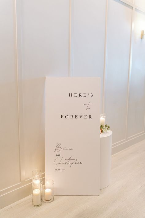 White Here's to forever welcome sign black script Day Of Signage Wedding, Wedding Signage Fonts, Modern Elegant Wedding Signage, Sinages Design For Wedding, Minimalistic Modern Wedding, Welcome Sign To Wedding, Fun Welcome Wedding Signs, Minimal Wedding Sign, Entrance To Wedding Reception