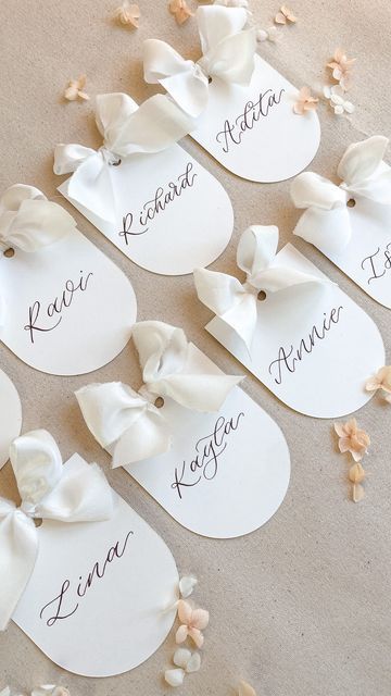 Frankie H | Wedding Signage & Stationery on Instagram: "Cutie little arched matte place cards with silk ribbon bows ✨ Ribbon from @cfleursdesign #placecards #weddingplacesetting #weddingplacecards #weddingbow" Wedding Seating Place Cards, Bow Name Cards, Bow Place Cards, Wedding Name Tags Ideas, Wedding Place Card Ideas, Wedding Bridal Table, Place Card Ideas, Wedding Table Name Cards, Calligraphy Place Cards