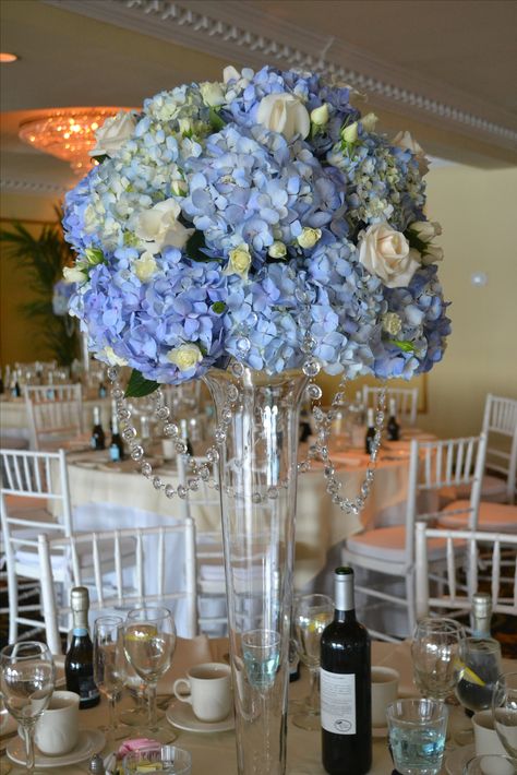 Wedding centerpiece with blue hydrangea and white roses, by Terri's Flower Shop in Naugatuck, CT. Blue Hydrangea And White Roses Flower Arrangements, Wedding Centerpieces Blue, Purple Hydrangea Wedding, Blue Hydrangea Centerpieces, Centerpieces Blue, Hydrangea Centerpiece Wedding, White Hydrangea Centerpieces, Rose Centerpieces Wedding, Spring Wedding Outfit