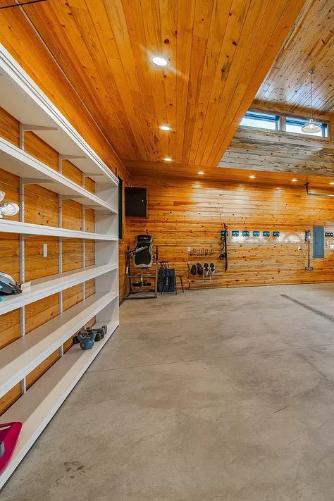 This spacious wood-paneled garage is a dream come true for any car enthusiast. With plenty of storage space and a clean, finished look, this garage is perfect for parking your car, working on projects, or even relaxing. #dreamgarage #garage #woodpaneling #storage #cars #carstorage #workshop #mancave #homeimprovement #organization #interiordesign #homedecor #luxuryhomes #goals #epoxyflooring #garagegoals #homegym #automotive Wood Storage Garage Wall, Wood Panel Garage Walls, Pole Barn Shop Interior Walls, Garage Interior Walls Wood Boards & Planks, Workshop Mancave, Car Garage Workshop Aesthetic, Pallet Wood Garage Walls, Garage Wall Storage, Garage Storage Inspiration