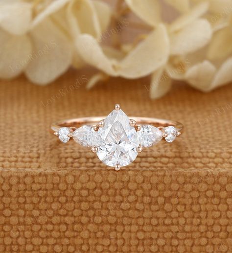 Pear shaped moissanite engagement ring Unique vintage Rose gold engagement ring Cluster diamond wedding ring Bridal Promise Anniversary gift ITEM DESCRIPTION: Center stone:l Moissanite Size:6*8mm Shaped: Pear cut Side stone: 0.28ct moissanite  or diamond Color/Clarity: E-F,SI1-VS Width of band: 1.6mm Thickness of band: 1.2mm Total weight: 2.3g Materials (can select from drop-down menu): 14K Solid gold/ 18K Solid gold ( Rose gold, Yellow gold, White gold) Size: all ring sizes are available, pleas Gold Pear Engagement Rings, Moissanite Pear Engagement Ring, Unique Engagement Rings Rose Gold, Pear Moissanite Engagement Ring, Rose Gold Moissanite Ring, Moissanite Engagement Ring Rose Gold, Rose Gold Engagement Ring Vintage, Engagement Rings Twisted, Ring Cluster