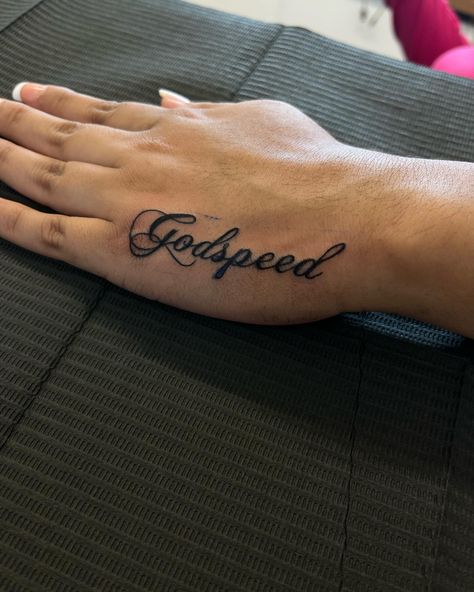 Godspeed🪽 • DM TO BOOK, BOOKING FOR JULY DEALS DROPPING SOON! #ladysmokeinkk #godspeed #firsttattoo #handtattoo #small #cute #girltattoos #girlythings #tatinspo #chopinscript #dmtobook #blackink #dynamicink #ambitionrotary #chicago #midway #girlswhotattoo #explorepage #foryoupage Fancy Writing Tattoo, Godspeed Tattoo Stencil, Godspeed Tattoo Font Design, Godspeed Neck Tattoo, Small Baddie Tats Hand, Godspeed Hand Tattoo, Cutesy Tattoos, G Tattoos, Small Name Tattoo