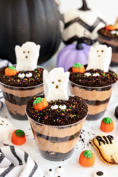 Looking for a spooky, fun, and easy treat to serve at your next Halloween party? These Graveyard Pudding Halloween Dirt Cups are perfect for kids and adults alike! Halloween Treats Dirt Cups, Halloween Pudding Dirt Cups, Dirt Cup Halloween, Halloween Cup Dessert, Dirt Cake Shooters, How To Make Dirt Cups, Halloween Dirt Pudding Cups, Spooky Dirt Cups, Graveyard Dirt Cups