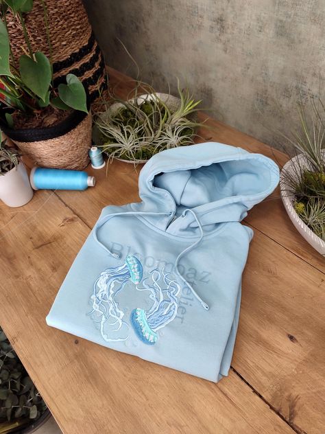 Hey, I'm happy to share my new project with you :)  Water Color Jellyfish Embroidered on Crewneck Sweatshirt, Hoodie Inspired by nature, organic elements and love.  Here's how to wash and take care of your next favorite sweatshirt/hoodie:  1. When to wash the sweatshirt ? I personally don't think that you need to wash it after every use. It needs to be washed after a few wears (five or six).  2. Which washing machine program should you use?  Turn the sweatshirt inside out and use the delicate or hand wash programs to respect the material. Unisex size for adults. Unisex size with variable sizes from XS to 3XL. Enjoy and contact me if you have any questions! Hoodie Embroidery Ideas Aesthetic, Embroidered Jellyfish, Blue Clothes Aesthetic, Hoodie Design Inspiration, Hoodie Inspiration, Blue Hoodie Outfit, Washed Sweatshirt, Embroider Ideas, Hoodie Diy