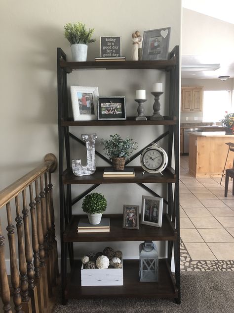 Farmhouse decor ladder shelf Bookshelves Farmhouse Style, Decorating Standing Shelves, Ladder Book Shelf Ideas, Basement Shelf Decor, Bookshelf Styling Living Room Farmhouse, Decorating Ladder Shelves In Living Room, Tiered Bookshelf Decor, Ladder Bookshelf Decor Living Room, What To Put On A Ladder Shelf