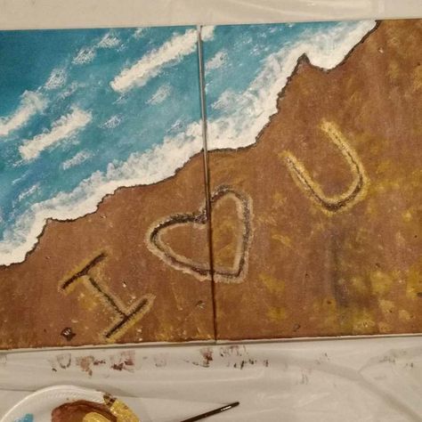 This is a split canvas painting. The whole painting is turquoise blue waves crashing into a sandy beige shore. A message is written in the sand with light tan. The message spells out I - heart in the middle and the letter U. Painting For Two People, Writing In The Sand Painting, Matching Couple Painting Ideas, Couples Easy Painting Ideas On Canvas, Connecting Canvas Painting Ideas, Couple Painting Ideas To Do Together, Painting Ideas On Canvas Couples Love, His And Her Painting Ideas, Painting Date Night Ideas