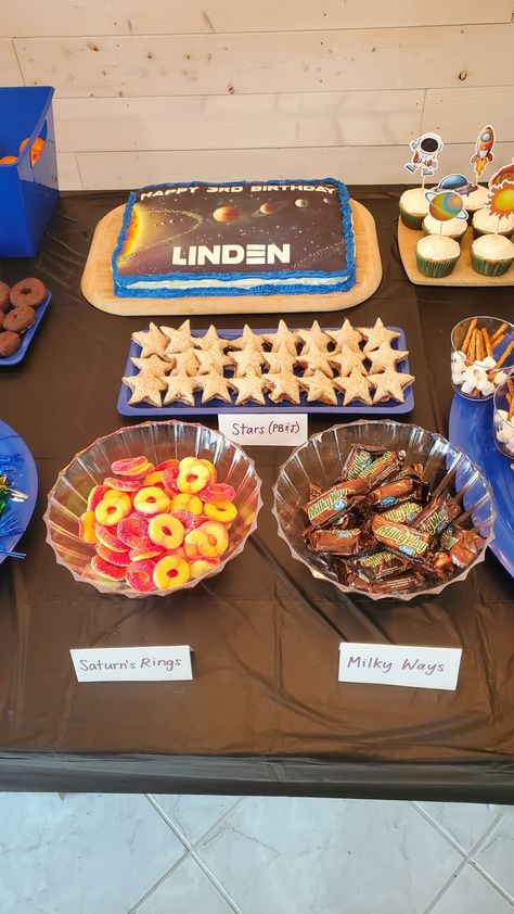 Here is some of the space-themed food we had at my 3 year old's birthday party! #space #solarsystem #spaceparty #spacefood Out Of This World Theme Birthday, Outer Space First Birthday Party Food, Space Party Appetizers, Two Space Birthday Party, Astronaut Birthday Food, Astronaut Food Party, Planet Themed Food, Astronaut Birthday Party Food, Space Themed Fourth Birthday