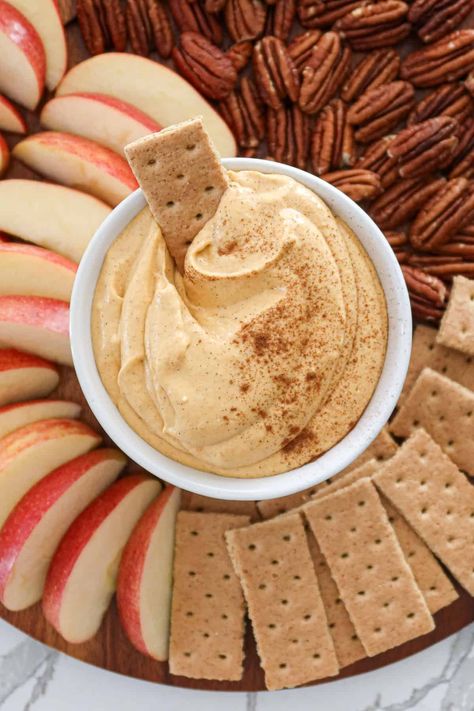 Easy no bake pumpkin cheesecake dip is a fall favorite. Pair with apple slices, graham crackers, pecans, pretzels, ginger snaps, nilla wafers and more! This simple recipe also makes a great spread for french toast and pancakes. I love serving pumpkin dip during spooky season and at holiday parties. It's great for Halloween, Thanksgiving and even Christmas! This cold dip is basically dessert but it's the best healthy option, sweetened with just a touch of maple syrup and no refined sugar. Thanksgiving Dip Dessert, Pumpkin Dip Cool Whip, Homemade Apple Dip, Pumpkin Apple Dip, Sweet Dips For Parties Fall, Healthy Snacks For Thanksgiving, Pumpkin Fluff Dip With Cream Cheese, Dairy Free Pumpkin Dip, Pumpkin Cream Cheese Spread