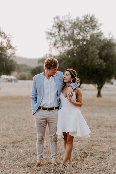 Casual and laidback wedding outfit ideas with the groom in khakis and a light blue blazer and the bride in a short and strappy wedding dress Summer Wedding Groom Attire Casual, Casual Bride And Groom Attire, Groom Summer Wedding Attire, Summer Wedding Groom Attire, Summer Groom Attire, Laidback Wedding, Strappy Wedding Dress, Casual Wedding Groom, Beach Wedding Groom Attire