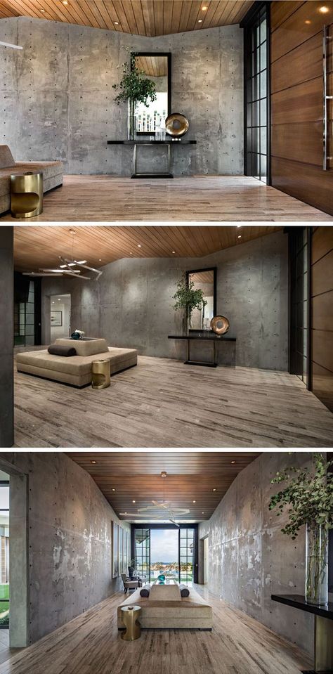 Stepping inside this modern house, a raw concrete wall lines the entryway, while windows at the end of the space provide water views. #ModernEntryway  #ModernDesign #ModernBathroom #Bathrooms #NashvilleInteriorDesigner #lighting #Naturalelements #DIY #Des Concrete Wall House, Cement Interior Design Living Room, Living Room Concrete Wall, Dark Concrete Wall, Polished Concrete Bedroom, Concrete Interior Design Living Room, Raw House Design, Concreat Walls, Concrete Block Interior