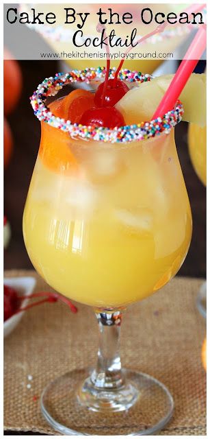 Cake By the Ocean Cocktail ~ With its fruity tropical flavors, cake vodka, & playful sprinkles rim, this summer cocktail is just plain fun to drink! #cakebytheocean #cocktails #happyhour #summercocktails #summerdrinks #cakevodka #thekitchenismyplayground  www.thekitchenismyplayground.com Cake By The Ocean Cocktail, Pineapple Flavored Vodka Drinks, Summer Boozy Drinks, Summer Time Drinks Alcohol, Simple Fruity Alcohol Drinks, Pinnacle Cake Vodka Recipes, Best Drinks For The Beach, Creative Mixed Drinks, Beach Themed Drinks Cocktails