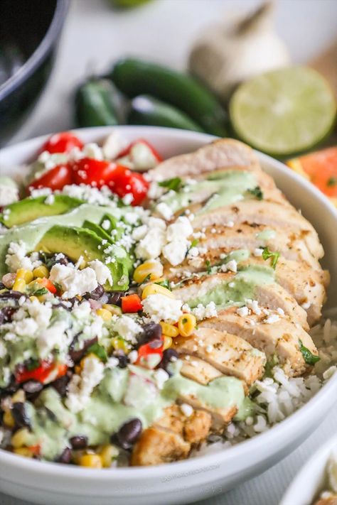 The ultimate fresh and fantastic dinner? Baja Bowls! With tender, full-of-flavor baja chicken over rice, black bean and corn salsa, veggies, and more then smothered in a creamy and tangy cilantro sauce, these baja chicken bowls are irresistible! If you love the Baja Bowl from Panera or Costa Vida, you have to try our at-home version. Baja Bowls, Baja Bowl, Baja Chicken, Black Bean And Corn Salsa, Chicken Over Rice, Black Bean And Corn, Chicken Bowls, Cilantro Sauce, Corn Salsa