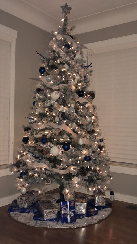 Our first Christmas tree in our first home! Blue, silver and white is the theme this year! #winterwonderland #christmasdecor Small Blue Christmas Tree, Blue Christmas Lights On Tree, White And Light Blue Christmas Tree, White Christmas Tree Blue Ornaments, White Silver And Blue Christmas Tree, White And Light Blue Christmas Decor, White Silver Light Blue Christmas Tree, Blue Silver White Christmas Tree Decor, Luxury Christmas Tree Decorations