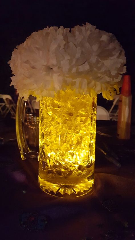 Beer centerpiece.  Cubes from M2 polymer. LED submersible from Amazon. Mug from Dollar Tree. 7 silk carnation. Foam piece for carnations. Beer Mugs Centerpieces, 40th Bday Table Centerpieces, Cheers And Beers Centerpiece, Simple Mens Birthday Decorations, Beer Glass Centerpiece, Modelo Beer Centerpieces, Beer Mug Centerpiece Table Decorations, Beer Table Decorations, Beer Can Centerpieces