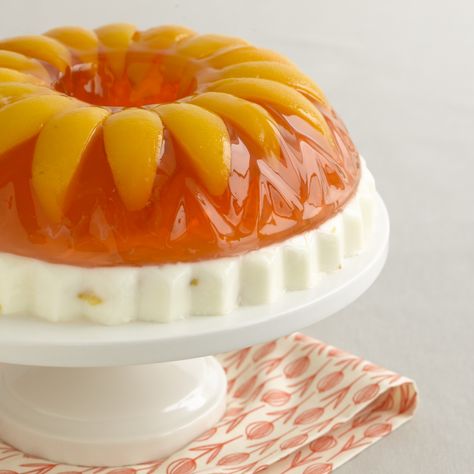 Peaches and Cream- this retro treat is made with a layer of sweetened condensed milk topped with peach gelatin and sliced peaches (with an option to add a little schnapps to the top layer if you like) Layered Jello Mold Recipes, Jello Deserts, Peach Jello, Jello With Fruit, Jello Mold Recipes, Jello Dessert Recipes, Jello Cake, Gelatin Recipes, Gelatin Dessert