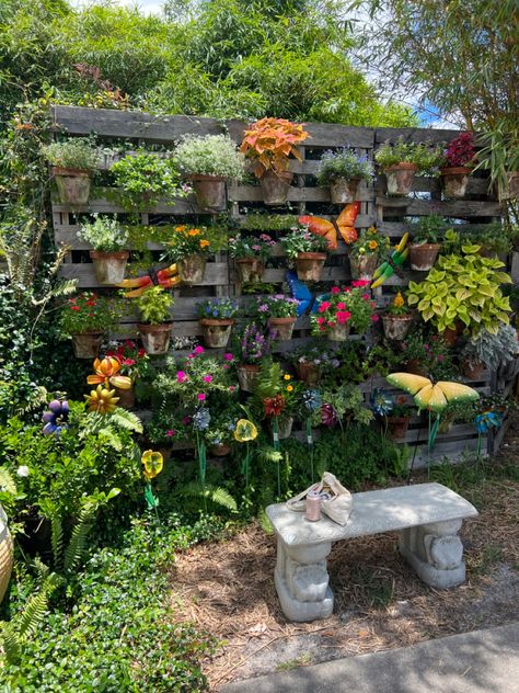 outside sitting area with butterfly statues and potted plants as the backdrop. Hidden Sitting Area Garden, Arbor Sitting Area, Garden Sitting Area Ideas Diy, Garden Hangout Area, Forest Seating Area, Pretty Garden Ideas Backyards, Creative Yard Ideas, Diy Outdoor Sitting Area, Outdoor Corner Ideas