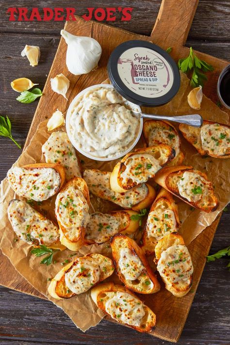 A tub of Trader Joe's Syrah Soaked Toscano Cheese Spread sitting on a cutting board covered with toasted cheesy baguette slices. Trader Joes Recipes Dinner, Trader Joes Appetizers, Bowl Of Spaghetti, Trader Joes Snacks, Trader Joes Food, Homemade Garlic Bread, Trader Joes Recipes, Dinner Party Recipes, Spread Recipes