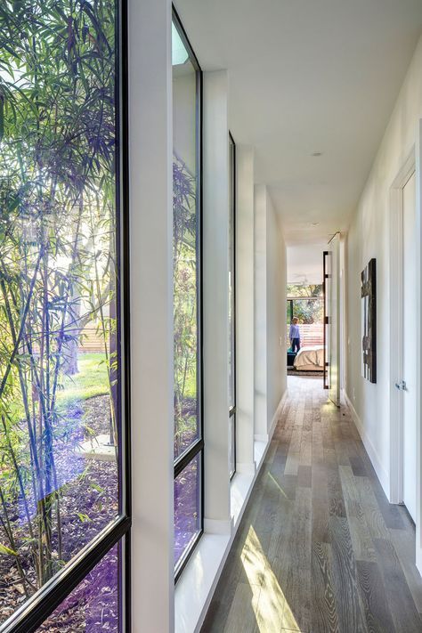 This modern hallway with floor-to-ceiling windows connects the master bedroom with the rest of the house. Bedroom Lighting Ceiling, L Shaped House Plans, L Shaped House, Modern Family House, Casa Country, Long Hallway, Modern Hallway, Big Windows, Bedroom Ceiling Light