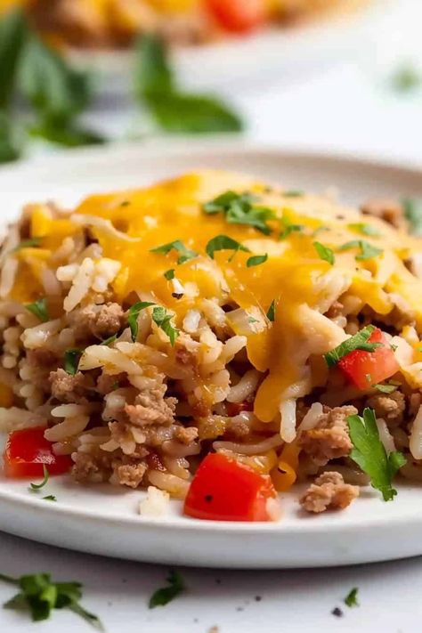 A generous serving of Ground Turkey and Rice, neatly plated on a crisp white dish, showcasing the rich blend of seasoned ground turkey and fluffy rice, all beautifully crowned with a layer of melted cheese. Ground Turkey And Rice, Seasoned Ground Turkey, Recipes Using Ground Turkey, Ground Turkey Casserole, Turkey And Rice, Chicken Broccoli Stir Fry, Ground Turkey Soup, Turkey Rice, Hotdish Recipes