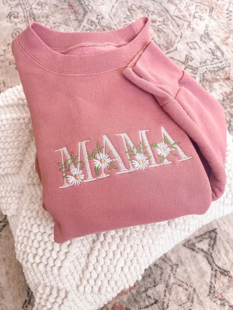 Crafted with love, this 100% Cotton Pink Sweatshirt adds comfort and warmth to any mom's wardrobe. The word 'Mama' is elegantly embroidered across the front, enhanced by a string of dainty daisies that wrap around each letter. This sweatshirt is not only comfortable but also a fashion statement. Its cozy crewneck makes it perfect for those chilly days or relaxed evenings at home. The Floral Mama Sweatshirt is an ideal gift for any occasion Valentines or Mother's Day. Mom Personalized Gifts, Embroidery Machine Projects, Embroidering Ideas, Motherhood University, Mama Embroidered Sweatshirt, Best Mom Gifts, Mama Embroidery, Mom Christmas Gifts, Embroidery Machine Designs