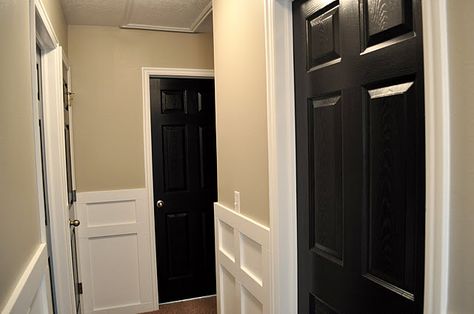 I am in love with the white board-and-batten, beige walls, and black doors!  I never would have thought to paint interior doors black, but it looks fabulous! House Black Interior, Hallway With Black Doors, Getting Replaced, Painting Interior Doors Black, Dark Doors, Black Interior Doors, White Molding, Stained Doors, Kitchen Dinning Room