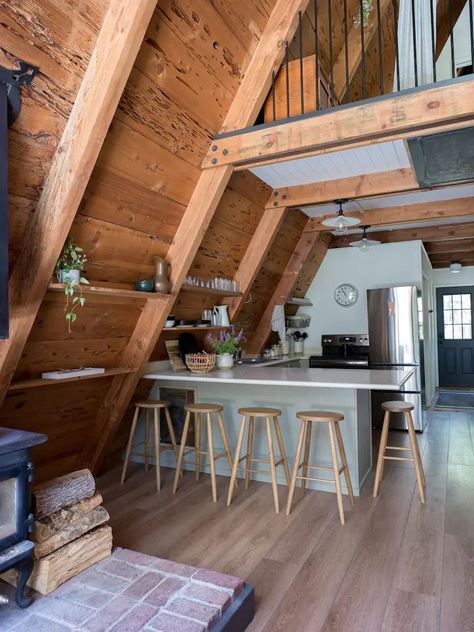 A Frame Cabin Loft Bedrooms, Cozy Aframe Cabin, A Frame Interior Kitchen, Lake House A Frame Interior, A Frame Fireplace Ideas, A Frame Lake Cabin, Airbnb A Frame, A Frame Cabin Layout, Aframe Cabin Interiors