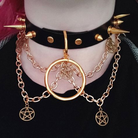 "\"Risen\" is the brass twin to \"Fallen\". \"Risen\" is a stunning statement piece, featuring a hanging 1.5 inch O-ring, 5 small pentacle charms, and 4 brass chains. It's the perfect addition to any punk, goth or grunge outfit, sure to help make you the life of the party (or make it rain compliments at the mall ;] ). The choker in the photos is 16 inches long, with 4 buckle settings at .75 inch spacing. You are welcome (and encouraged!) to request custom measurements, as these are entirely handmade and can be made to order. Sizing note: The preset options listed are for the MAX size setting. For example, if you order a 20 inch choker, the largest setting will be 20 inches, and the smallest will be 17. Please be sure to measure your neck to ensure a proper fit! If you're unsure how to meas Alt Style Outfit, Shiny Jewelry, Grunge Outfit, Alt Outfits, At The Mall, Make It Rain, Costume Patterns, Ring Der O, Life Of The Party