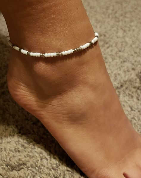 Savaya Anklet Ankle BraceletThe Savaya Shell anklet is a piece with a delicate design, dotted with white seed beads and centered with a tiny seashell piece. * Pattern centered with shell beads & silver accents. * Handmade in Bali. Adjustable to approximately 10" plus 4" sliding knot extension. Diy Anklets, Tiny Bead Bracelet, Ankle Bracelets Diy, Bead Anklet, Beaded Ankle Bracelets, Crystal Anklet, Beaded Ankle, Denim Jewelry, Key Holders