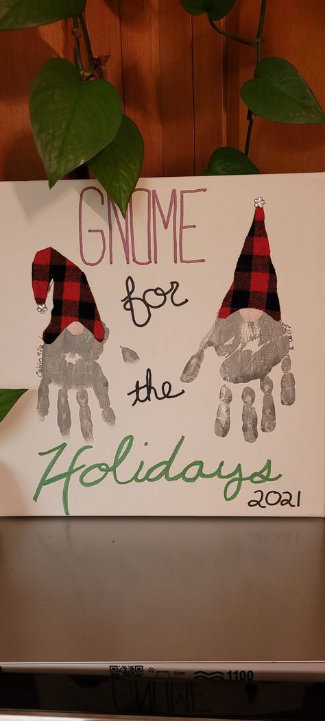 You can't tell from the photo, but I actually use silver sparkle spray paint lightly dusted around the edges! Canvas Christmas Presents From Kids, Christmas Gnome Handprint Craft, Gnome Hand Print Crafts For Kids, Hand Gnome Craft, Christmas Hand And Feet Art, Hand Print Gnome Craft, Gnome Footprint Art, Baby Canvas Painting Ideas Hand Prints Christmas, Hand And Foot Print Art For Kids Christmas