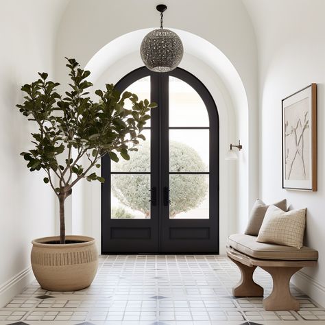 spanish inspired modern entryway with larger arched iron doorway & oversized planter with Spanish olive fig tree Modern Spain Interior Design, Spanish Foyer Entryway, Modern Mediterranean Foyer, Arched Foyer Entryway, Modern Spanish Transitional, European Style Entryway, Spanish Colonial Entryway, Spanish Modern Homes Kitchen, Mediterranean Entryway Decor