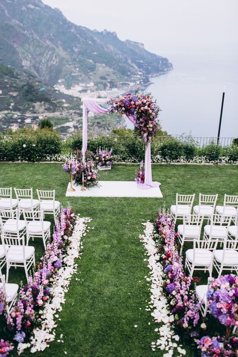 Stunning wedding arch and aisle decor with gorgeous purple florals and fabric draping. Lila Wedding Decoration, Fabric Draping Wedding, Wedding Ceremony Places, Purple Wedding Ceremony, Lilac Wedding Themes, Lavender Wedding Theme, Rapunzel Wedding, Purple Wedding Decorations, Draping Wedding