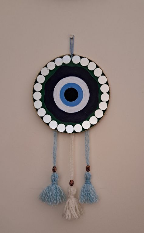 Used a mdf board to make this.Acrylic colors and woollen tassels. Added mirrors to make it eye catchy. Beautiful simple easy💕💕 Mdf Board Mirror Art, Evil Eye Dream Catcher Diy, Creative Craft Ideas Diy Projects, Project Making Ideas, Handmade Creative Wall Decor, Mdf Board Painting Ideas, Clay Art Easy, Evil Eye Diy, Mirror Canvas Art