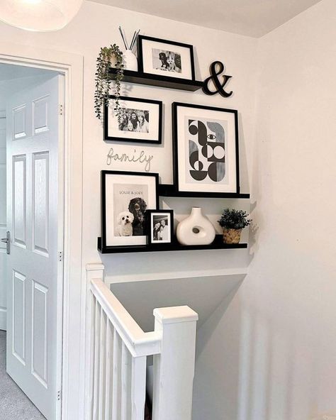 Last on our list is a gallery wall on floating shelves. They’re decked out with a mix of black and white framed artworks and photographs, giving off a modern minimalist vibe. Image credit: INSTAGRAM @OUR_HANBURY_HIDEAWAY Picture Wall Ideas Small Space, Shelves Above Stairs, Wall At Bottom Of Stairs Decor, Small Landing Decor Upstairs, Hall Ways Ideas Entrance Modern, Floating Shelves Gallery Wall, Black And White Wall Ideas, Black And White Frames On Wall, Gallery Picture Wall