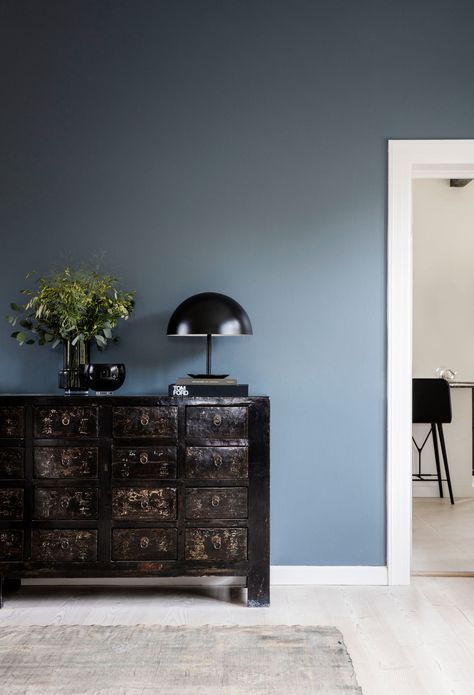 Colour is briefly introduced in the living room, which has a slate-blue feature wall and murky green painting by artist Anette Wier. Copenhagen Interior, Blue Feature Wall, Blue Walls Living Room, Feature Wall Living Room, Living Room Wall Color, Room Wall Colors, Painted Walls, Neutral Living Room, Plywood Furniture