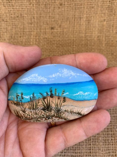 This hand painted beach rock has a sand dune beach scene with beach grass and ocean waves. The back of the rock is painted white so you can add a personalized message if you want. Approximate Size: 3” x 1 1/2” Because Nature never creates identical rocks and all our rocks are individually painted pieces of art, each rendition may vary slightly from the item pictured. Please allow for any subtle differences that make handmade items so special. We do not mass produce our work, each piece is uniqu Painted Rock Animals, Stone Art Painting, Rock And Pebbles, Painted Rocks Craft, Painted Rocks Diy, Rock Painting Ideas Easy, Rock Painting Patterns, Beach Rocks, Hand Painted Stones