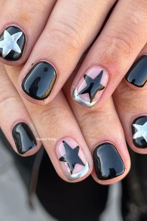 These short, rounded nails present a chic and playful contrast. A glossy black base gives a classic, sophisticated look, while pink nails with bold black stars add a pop of whimsy. Metallic silver embellishments outline some of the designs, providing a striking frame that ties the look together seamlessly. It's a modern twist on a starry night theme, full of style and fun! ✨  // Photo Credit: Instagram @blendedbeauty.mb Silver Nails With Black Stars, Metallic And Black Nails, Cute Manicures For Short Nails, Pop Star Nails, Black Silver Star Nails, Nail Inspo Black And Silver, Short Nail Star Designs, Black Nails With Silver Stars, Black Simple Nail Designs