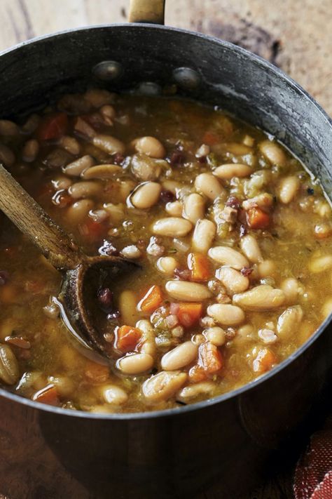 Ina Garten's Tuscan White Bean Soup is made with cannellini beans, pancetta, leeks, onions, carrots, celery, garlic, rosemary, chicken stock, and Parmesan cheese. This hearty Tuscan White Bean Soup recipe creates a delicious dinner that takes about 2 hours , including soaking time, to prepare and can serve up to 6 people. Ina Garten Tuscan Bean Soup, Ina Garden Tuscan White Bean Soup, Ina Garten Tuscan Soup, Ina Garten Vegetable Soup, Garlic Bean Soup, Ina Garten Tuscan White Bean Soup, Cannellini Bean Soup Recipes, Tuscan Bean Soup Recipe, Ina Garten Soup Recipes