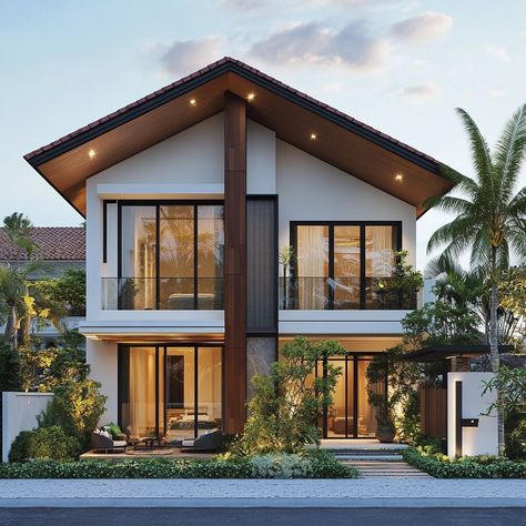 This modern duplex house showcases the beauty of simplicity, with a white facade and dark window frames enhanced by warm wooden details. The sloped roof and tropical landscaping add to the home’s inviting charm, especially under the soft evening light. #ModernSimplicity #DuplexLiving #TropicalDesign #WarmAccents #EveningCharm Duplex Facade Design, Filipino House Exterior, Duplex Landscaping, Duplex House Exterior, Dark Window Frames, Tropical Modern House, Modern Duplex House, White Facade, Japan House Design