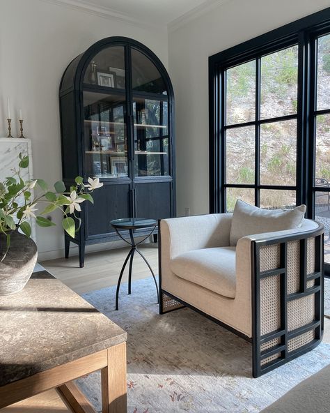 Display Cabinet In Living Room, Living Room Black Accents, Cabinet Living Room Decor, Armoire In Living Room, Hutch Living Room, Black Arched Cabinet, Lounge Chair Living Room, Cabinet Styling, Black Lounge Chair