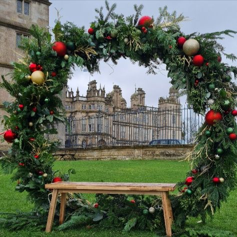 Giant Christmas Wreath Red Gold and Green Giant Wreath Backdrop, Huge Christmas Ornaments, Oversized Christmas Wreath Outdoor, Christmas Photo Opportunity Ideas, Christmas Decorations Event, Giant Christmas Wreaths, Greenhouse Christmas Decor, Christmas Installation Outdoor, Diy Christmas Market Stall