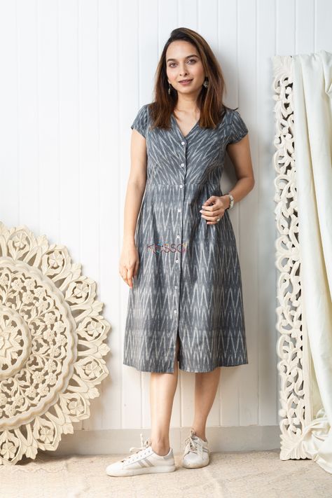 Cut in a distinct mid length A-line silhouette, the ikat grey mid-length dress is carefully handwoven with a dainty ikat pattern in grey and white tones. A great choice for daily-wear, this soft cotton outfit is embellished with front buttons, side pleats and V-neck. The dress comes with two side pockets. Ikat One Piece Dress, Front Button Frock Design, Cotton Daily Wear Dresses, Daily Wear Kurtas Cotton, Ikat Cotton Dress, Cotton A Line Frocks For Women, Simple Daily Wear Kurti Design, Cotton Ikat Dress, Aline Cotton Dress