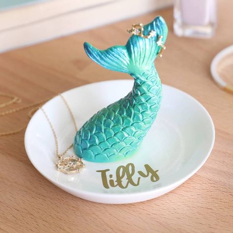 A magical mermaid tail trinket dish with name, from Lisa Angel Home. A wonderful spot to store your small jewellery pieces or trinkets, this dish features an iridescent green mermaid tail set onto a white ceramic base. Finished with a gold vinyl sticker name. Simply hang your items on the tail or place on the base. Character limit: up to 8 characters.  resin Jewelry Storage Diy, Stackers Jewellery, Jewelry Bowl, Mermaid Bathroom, Key Bowl, Jewellery Dish, Mermaid Ring, Dish Storage, Duck Pond