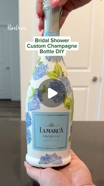 PureWow on Instagram: "Looking for a fun bridal shower idea? 🤍👰‍♀️ Gift the bride-to-be a DIY custom champagne bottle. 🍾

#DIY #customchampagnebottle #DIYchampagnebottle #bridalshowerideas #bridalshower #bridalshowergift" Mod Podge Champagne Bottle With Napkins, Painting Prosecco Bottles, Diy Prosecco Bottle, Diy Champagne Bottle Decorations, Bridal Champagne Bottle, Customized Champagne Bottle, Midge Podge Champagne Bottle, Diy Wine Bottle Painting, Custom Painted Champagne Bottle