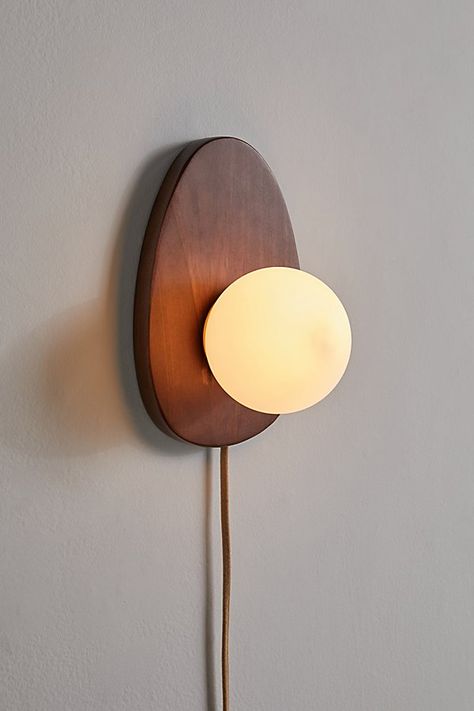 Refresh your lighting display with this statement sconce featuring a sculptural wood base topped with a milky glass shade. Plugs in to power on. Available exclusively at Urban Outfitters. Features Statement sconce from our Yoji lighting collection Sculptural base Milky glass shade Plug in UO exclusive Content + Care Wood, iron Wipe clean Imported Made in compliance with US electrical standards. To use this item outside of the US, pair with an outlet adapter and voltage converter made specifically for use in your location. Size Wattage/Voltage: AC 120V/60Hz Overall dimensions: 11.3" l x 7.4" w x 6.5" h | Yoji Sconce in Brown at Urban Outfitters Luminaria Diy, Plug In Pendant Light, Minimalist Lighting, Wall Sconces Bedroom, Sconces Bedroom, Organic Forms, Bedside Lighting, Wood Lamps, Lighting Collections