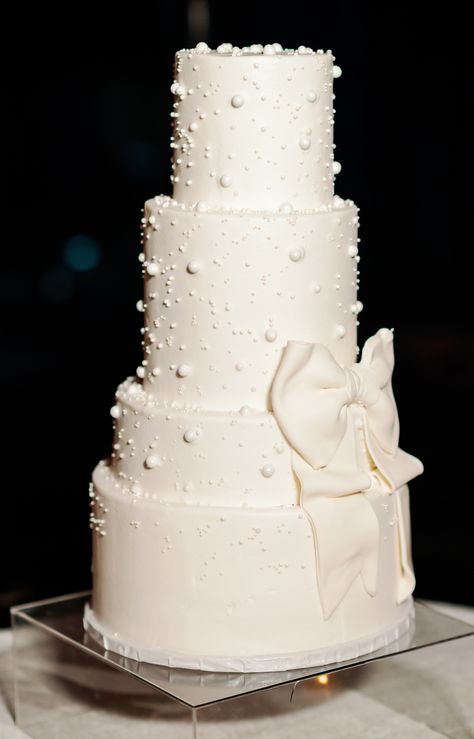 modern pearl and bow detail white wedding cake Wedding Cake Designs Pearls, White Wedding Cake With Bow, Pearl Cake Topper, Wedding Cakes With Bows, Black And Pearl Wedding, Bow Themed Wedding, Pearl Wedding Details, White Cake With Pearls, White Pearl Wedding Cake