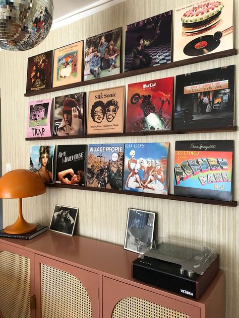 Record albums hung on picture ledges above sideboard with record player and lamp. Vinyls On Wall Aesthetic, Record Room Ideas, Record On Wall, Rocker Room, Record Player Wall, Vinyl Record Wall Display, Record Wall Display, Vinyl Record Shelf, Picture Ledges