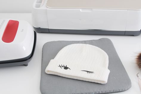 DIY cozy winter hats with removable pom-poms – Cricut iron-on Circut Ideas For Hats, Cricut Beanie Hats, Cricut Beanie Ideas, Beanies Cricut, Making Hats With Cricut, Iron On Hats Cricut, Htv On Knit Hat, Winter Hat Diy, Make Your Own Hat